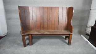 A C.1900 high backed pitch pine settle on square supports. H.128 W.161 D.57