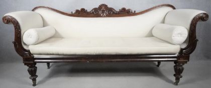 A William IV mahogany framed double scroll end sofa with palmette and acanthus carved back rail
