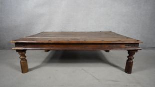 An Indian hardwood metal bound and studded low table on circular supports. H.46 W.102 D.92