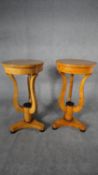 A pair of Biedermeier style burr maple lamp tables or urn stands on shaped supports resting on