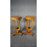 A pair of Biedermeier style burr maple lamp tables or urn stands on shaped supports resting on