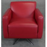 A retro vintage design swivel armchair in red leather upholstery on chrome supports. H.85cm