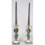 A pair of 19th century candelabras with gilt metal mounts and putti holding the flame aloft with cut