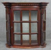 A Continental style mahogany wall hanging cabinet with glazed panel door flanked by spiral