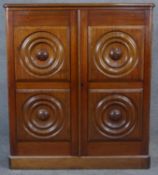 A 19th century Colonial teak dwarf cabinet with circular moulded panels and flowerhead roundels to
