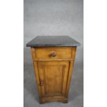 A late 19th century French oak pedestal cabinet with marble top above frieze drawer and panel door