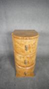 An Art Deco style burr walnut bow fronted pedestal chest of three drawers on shaped plinth base. H.