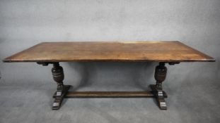 A Jacobean style oak refectory dining table with planked top and cleated ends on stretchered