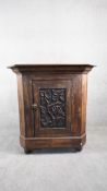 An oak Arts and crafts corner cabinet with floral relief carved panel door. H.94 W.87 D.54