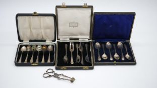 Three cased sets of silver cutlery and a pair of Georgian silver sugar nips. A cased set of six