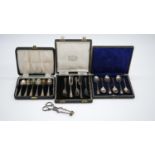 Three cased sets of silver cutlery and a pair of Georgian silver sugar nips. A cased set of six