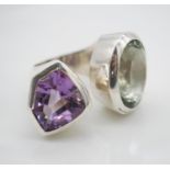 A bespoke sculptural wrap around silver and amethyst ring. One side set with an oval mixed cut green