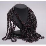 A bundle of ten strings of oval garnet beads. L.24"