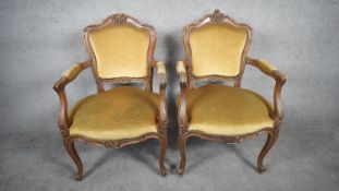 A pair of late 19th century walnut Rococo carved fauteuil in damask upholstery raised on cabriole