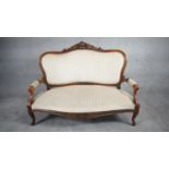 A Louis XV style mahogany framed sofa with floral carved backrail in cut flowerhead upholstery