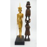 An antique Continental carved wooden candlestick in the form of two figures along with a gilded