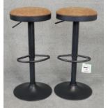 A pair of contemporary adjustable high stools in tan upholstery. H.80cm (full height)