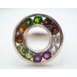 A white metal bespoke made multi gemstone halo ring. Set with coloured garnets, white sapphires