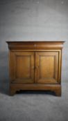 A 19th century French Provincial oak side cabinet with frieze drawer above panel doors on bracket