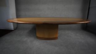 A large bespoke oval dining table in lacquered teak raised on pedestal base. H.75 W.272 D.151 (
