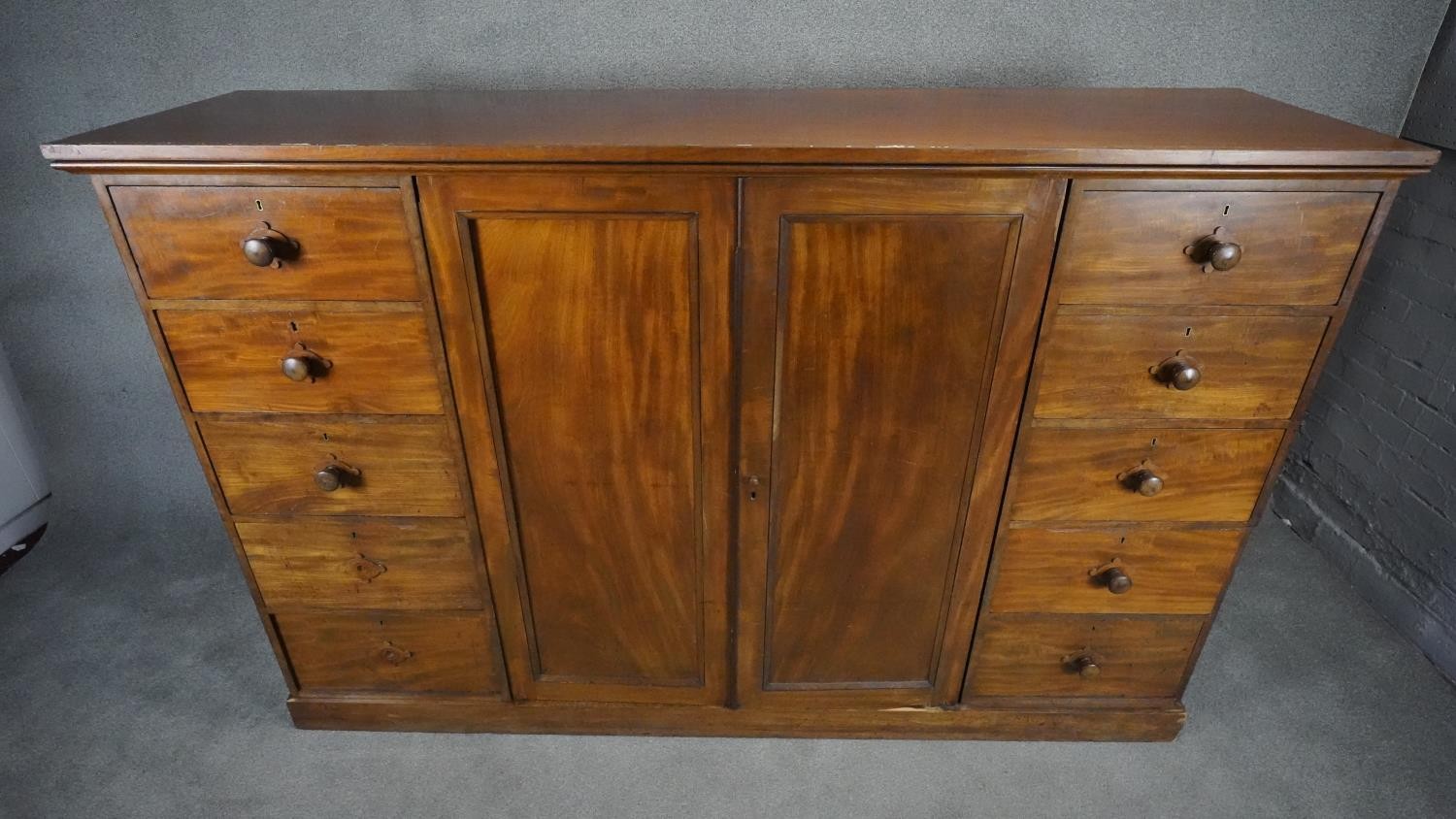 An mid 19th century mahogany linen cupboard with central panel doors flanked by two banks of four - Image 2 of 14