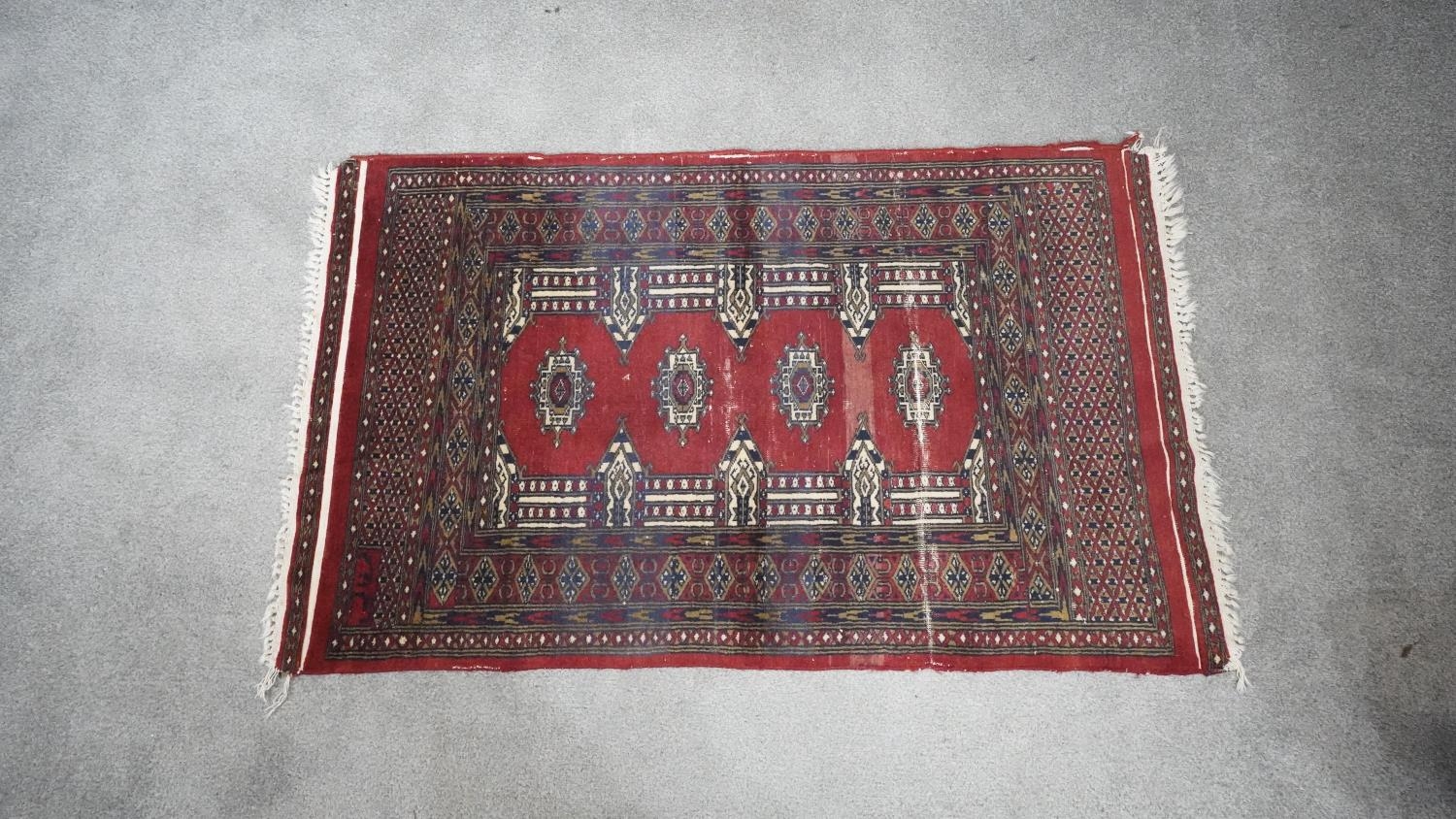 A signed Pakistan Bokhara rug with red ground within a central pendant motif. H.185 W.135 - Image 2 of 5