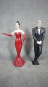 A pair of painted jointed fibreglass figures of a man and a woman in black tie dress. H.80 W.43