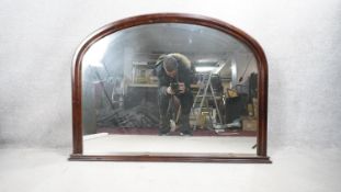 A 19th century style overmantel mirror in arched mahogany frame on stepped plinth base. H.82 W.105