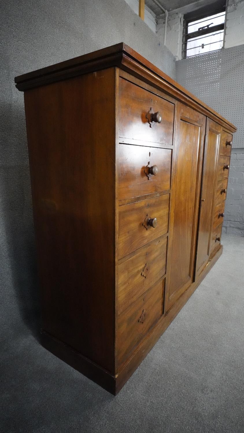 An mid 19th century mahogany linen cupboard with central panel doors flanked by two banks of four - Image 5 of 14