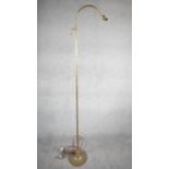A vintage solid brass height adjustable arched design standard lamp with weighted circular base