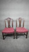 A pair of Georgian mahogany dining chairs with shaped, pierced and carved back splats above floral