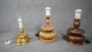 Three carved wooden and gilded table lamps. Including one with a stylised floral design. H.38