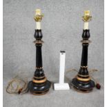 A pair of vintage lacquered metal table lamps with gilded detailing and floral design around the