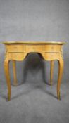 A Louis XV style burr maple kneehole writing table with ormolu mounts on slender cabriole