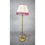 A vintage solid brass weighted base height adjustable standard lamp with silk wrapped cord and