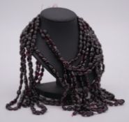 A bundle of ten strings of oval garnet beads. L.24"