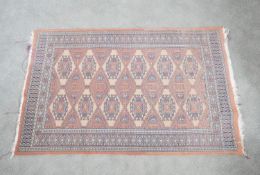 A Pakistan Bokhara rug with fawn ground and pendant motifs within a stylised border. H.91 W.150