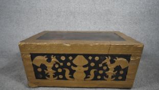 An Eastern teak trunk with twin metal carrying handles and embossed gilt metal decoration. H.30 W.60