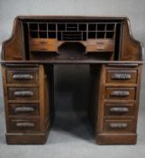 A 19th century oak roll top desk with serpentine tambour shutter and fitted interior on twin
