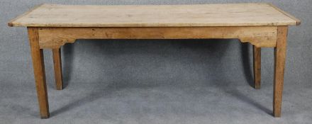 A 19th century pine refectory style farmhouse dining table with shaped frieze on square tapering