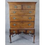 A Georgian oak and mahogany crossbanded chest on stand with shaped apron raised on cabriole pad foot