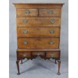 A Georgian oak and mahogany crossbanded chest on stand with shaped apron raised on cabriole pad foot