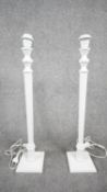 A pair of white painted wooden table lamps with reeded columns on square bases. Two pin plug. H.70