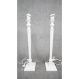 A pair of white painted wooden table lamps with reeded columns on square bases. Two pin plug. H.70