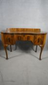 A mid century figured walnut Queen Anne style dressing table. H.88 W.121 D.52 (with faults as