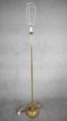 A vintage solid brass candle design height adjustable standard lamp with ridged weighted circular