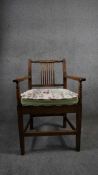 A 19th century country oak stick back armchair with fitted cushion on square tapering stretchered