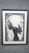 A framed and glazed signed limited edition wood block print of two skeletal hands. Indistinctly