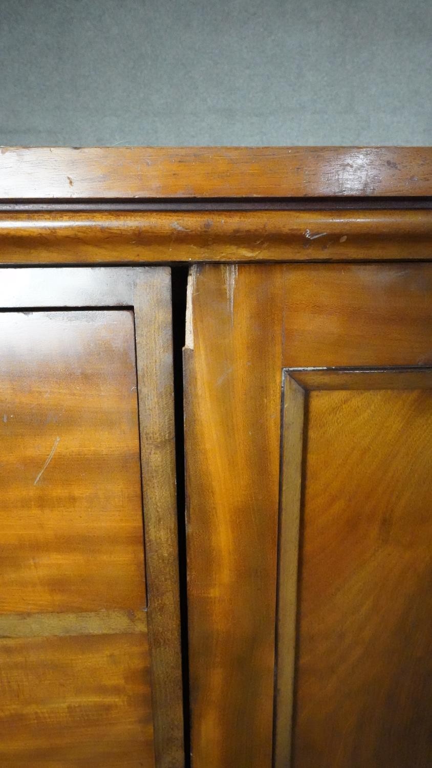 An mid 19th century mahogany linen cupboard with central panel doors flanked by two banks of four - Image 8 of 14