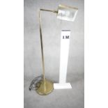 A vintage solid brass swing arm floor lamp with triangular shade, painted white interior and